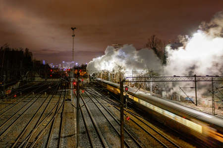 Night photo of an old steam locomotive walking along the railroad tracks. High quality photoの写真素材