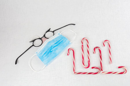 lollipops and medical masks, Christmas accessories on a white background. Take care of health...