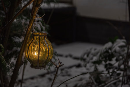 Flashlight with burning candles in the snow. Concept, winter, new year, christmas. High quality photoの写真素材