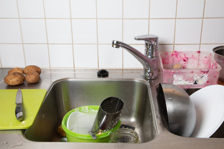 Dirty dishes in the sink prepared for washing Cleaning concept. High quality photo