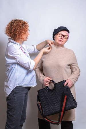 Personal stylist. Helps a client, a middle-aged woman, to choose a style. Clothes, fashion, style...