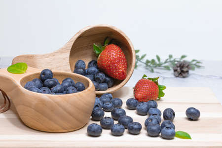 Fresh blueberries and strawberries in a wooden mug. Natural vitamins concept. High quality photo