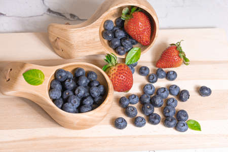 Fresh blueberries and strawberries in a wooden mug. Natural vitamins concept. High quality photoの写真素材