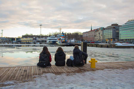 Finland, Helsinki February 26, 2021 view of the Gulf of Finland, view of Olympia terminal, teenagers on the pier. High quality photoのeditorial素材