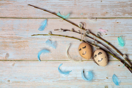 A beautiful composition for Easter of multi-colored feathers of flowers and eggs with a painted cute...