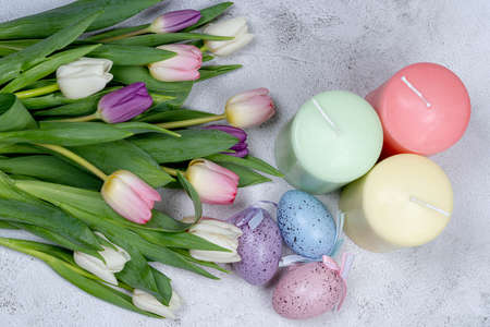 Easter eggs, candles, a bouquet of tulips from above on a gray background. Happy holiday concept ERの写真素材