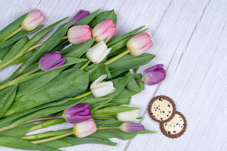 Sweet dissert and a bouquet of tulips, from above on a gray background. Happy holiday conceptの写真素材