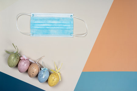 Layout, Easter eggs and a medical mask. Concept Easter lockdown, Coronavirus: new strain, stay at homeの写真素材