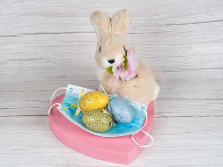 Colorful eggs around the rabbit. Happy Easter. Rabbit and medical maskの写真素材