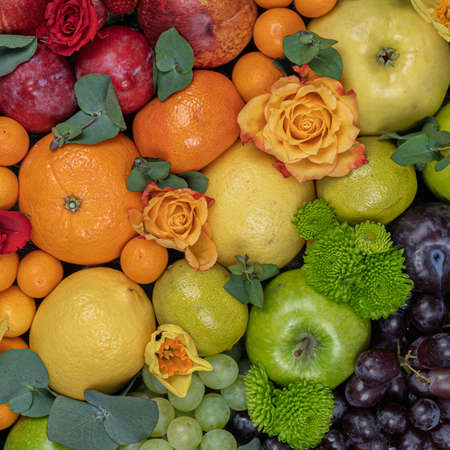 A large bouquet of fruits. Grapes, apples, oranges, kiwi, tangerines, pomegranates and flowers. View from above.の写真素材