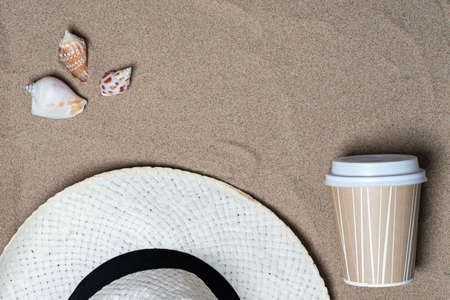 Hat, coffee cup, seashells top view, there is a place for text. Summer vacation concept by the seaの写真素材