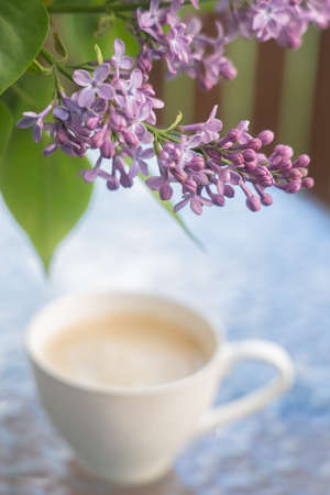 On the table a bouquet of lilacs and a cup of coffee Concept, relaxationの写真素材
