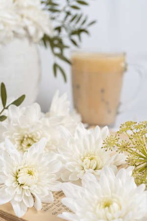 Still life with an old book, a cup of coffee and chrysanthemum flowersの写真素材