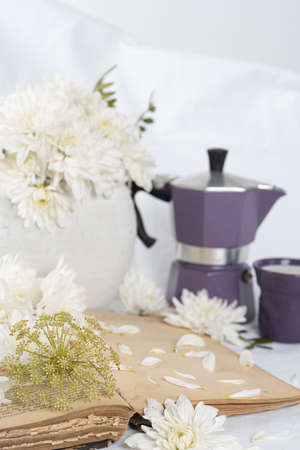 Still life with an old book, a cup of coffee and chrysanthemum flowersの写真素材