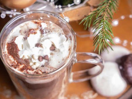 Hot chocolate, cocoa in a glass mug, against the background of Christmas decorations,