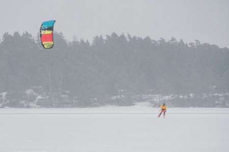 Finland. Espoo. January 29, 2022 . On the ice in the sea a kite surfer on skis, bad weather, strong wind and snowstormのeditorial素材