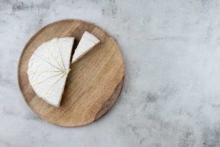 Top view, sliced round white cheese - a traditional dairy creamy dairy product on a wooden board plate. HOME, Country style.の写真素材