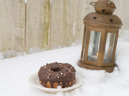 donut and lantern on snow spring concept. congratulations on March 8, Easter, Shrovetide