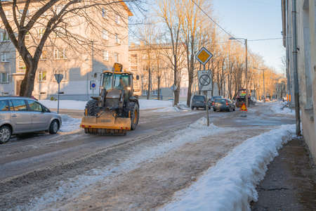 Narva Estonia 10 March 2022 . The tractor cleans the road from snow. Spring cleaning of the cityのeditorial素材