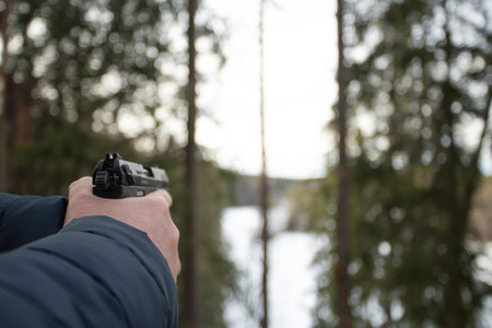 A man with a gun. gun in hand in the forest, hunter. the military waits for prey, the hunter shootsの写真素材
