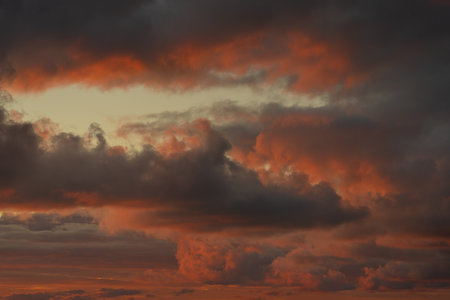 Sunset sky. Frightening dark clouds are illuminated by the red-orange light of the sun. beautiful sky. natural background.の写真素材
