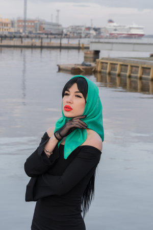 A brunette woman and red lips in a black dress, a bright scarf on her head. close-up portraitの写真素材