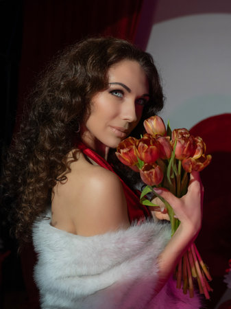 Beautiful girl with tulips on a red backgroundの写真素材