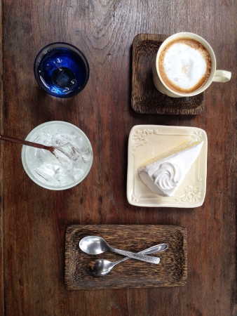 A cup of coffee with a piece of coconut cakeの素材