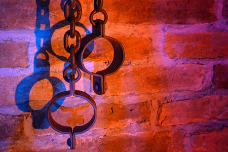 old chains and shackles on a red brick wall