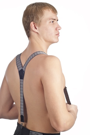Young guy posing in studio and undressing over whiteの写真素材
