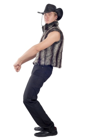 Young handsome man posing in studio in fur waistcoat and cowboyの写真素材