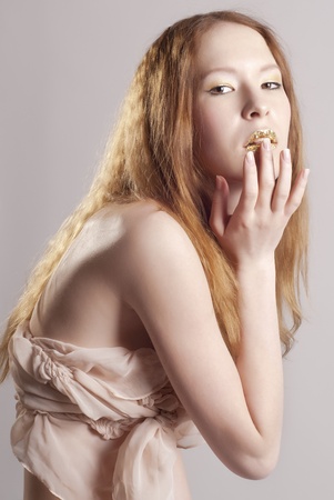 Beautiful woman with gold lips, posingの写真素材