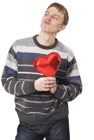 Young funny handsome man with red heart balloon over whiteの写真素材