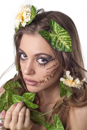 Portrait of beautiful young lady with flower and leaf  in her hair over whiteの写真素材