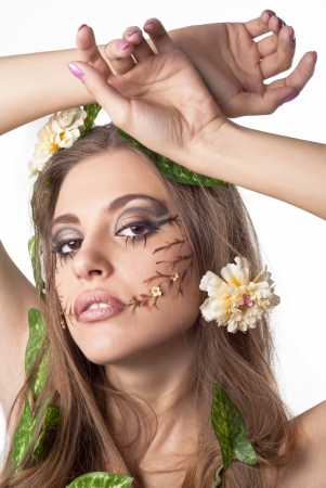 Portrait of beautiful young lady with flower and leaf  in her hair over whiteの写真素材