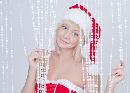 Beautiful smiling young woman in Santa Claus clothes with white beadsの写真素材
