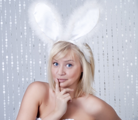 Beautiful smiling woman portrait with rabbit ears over white beadsの写真素材