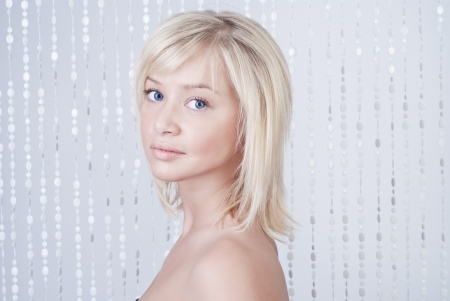 Beautiful woman with bead curtains, portraitの写真素材
