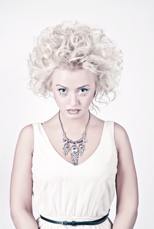 Attractive blond beauty in white dress with original make up and hair dressの写真素材