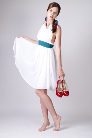 Beautiful young lady posing in white dress with bright accessoriesの写真素材
