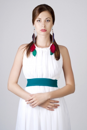 Beautiful young lady posing in white dress with bright accessoriesの写真素材
