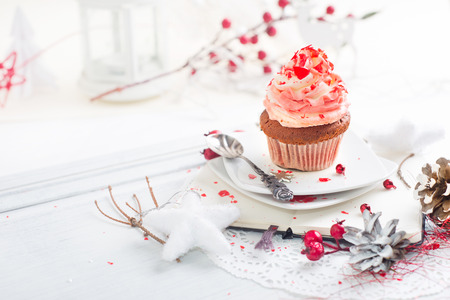 Cupcake with white and red cream over Christmas backgroundの写真素材