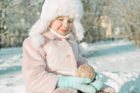 Little girl with Christmas toy outside in the park, with smile on face, joyful childの写真素材