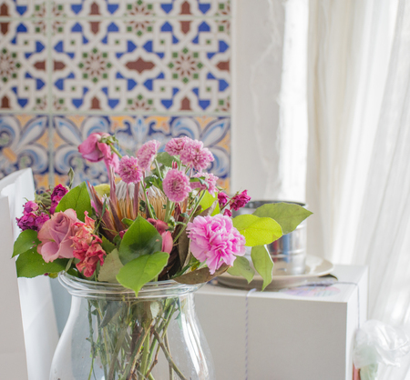 Flower bouquet on kitchen over light background, floral still life, bright spring flowersの写真素材
