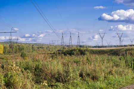 High voltage posts in scenic colourful autumn or late summer landscape, seasonal backgroundの写真素材