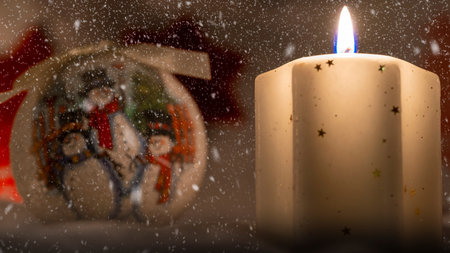 bright yellow decorative candle with christmas globesの写真素材