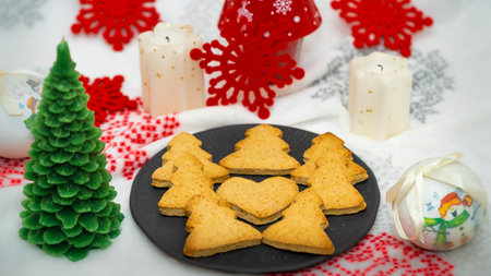 Christmas tree cookie with a background of globes, candles and red starsの写真素材