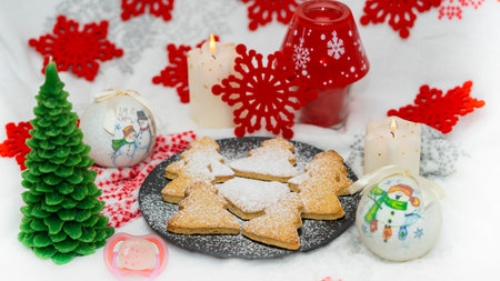 Christmas tree cookie with a background of globes, candles and red starsの写真素材