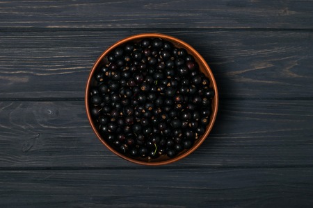 Black currant on wooden table with leaf sprigの写真素材