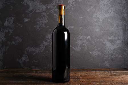 Red wine bottle on a wooden backgroundの写真素材